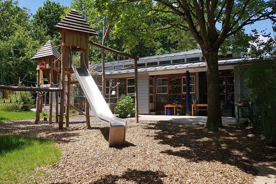 Garten mit Rutsche und Sicht auf Kinderhaus Berliner Ring