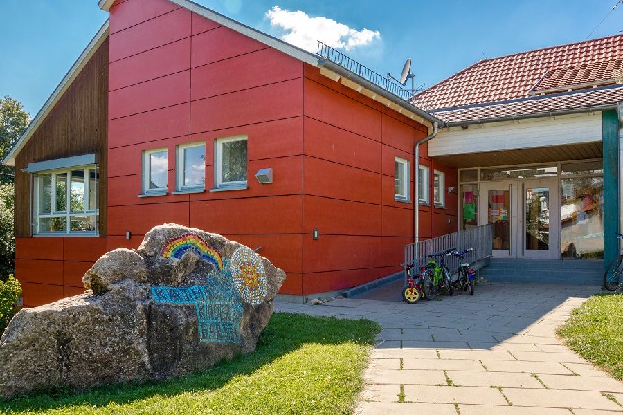 Eingang des roten Kindergartens St. Pankratius mit großem Stein
