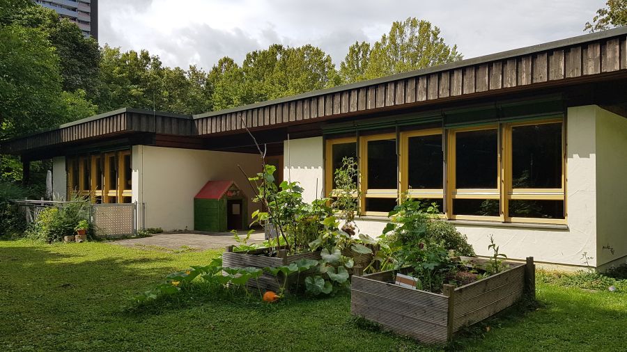 Blick auf Kinderhaus vom Garten aus mit Hochbeeten