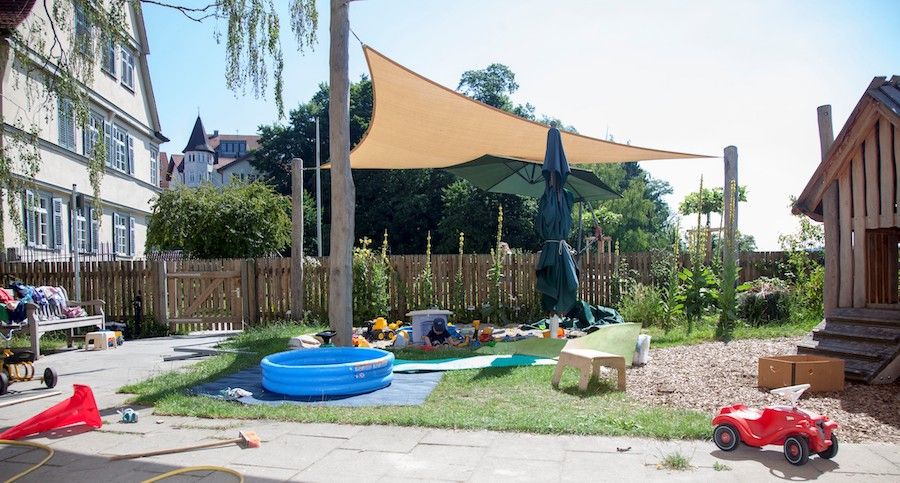 Garten des Kinderhauses mit Sonnensegel, Kletterhaus, Plantschbecken